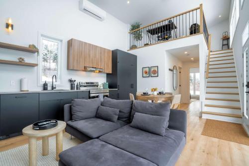 a living room with a couch and a kitchen at Modern Comfort - Spa - Mountain - Chalet KNOX in Saint Come