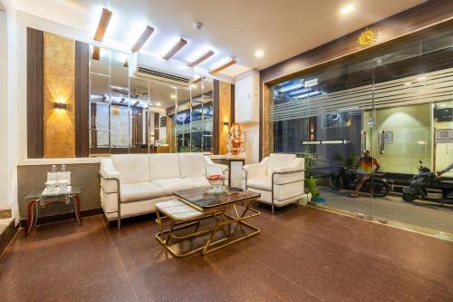 Una sala de estar con un sofá y sillas y una mesa. en Hotel Opera Delhi Airport, en Nueva Delhi