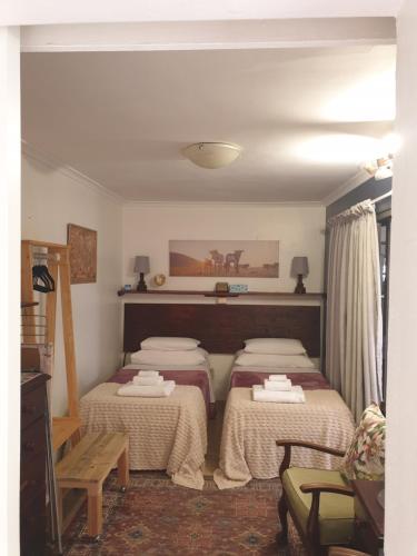 a room with three beds and a table and a couch at Hibiscus B&B in Strand