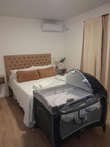 a bedroom with a bed with a suitcase on it at Departamento de Lujo a 8 min del centro in San Nicolás de los Arroyos