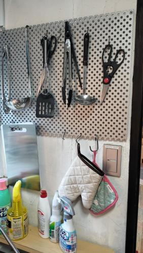 a wall with utensils hanging on a pegboard at 絶景ゴンドラヴィライン熱海1階 in Atami