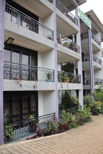 a large apartment building with balconies and plants at NL Josephine's Apartment in Kampala
