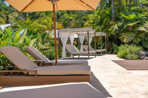 a row of chairs with umbrellas on a patio at NALA Resort in Mission Beach