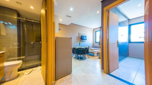 y baño con ducha, aseo y mesa. en Atlas-Résidence by Rent-Inn, en Rabat