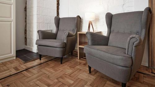 two chairs in a room with a table and a lamp at CityNest Apartments in Krakow