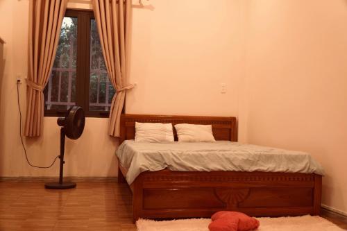 Cloudy homestay في Bảo Lâm: غرفة نوم بسرير خشبي مع نافذة