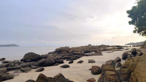 a group of rocks on a beach near the water at Bayside & Beach Inn Langkawi in Pulau Langkawi