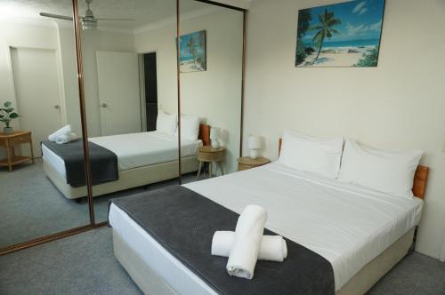 a bedroom with a large white bed with a mirror at Aussie Resort in Gold Coast