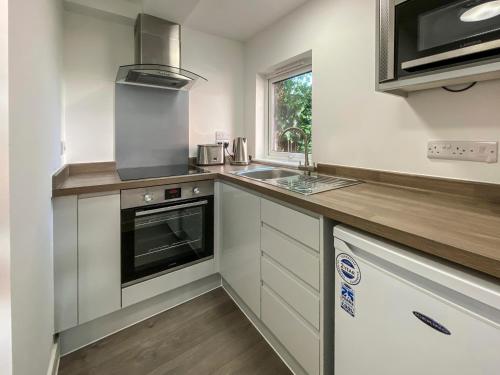una cocina con fregadero y estufa en City & Station Apartments at Gulland House by Pureserviced, en Plymouth
