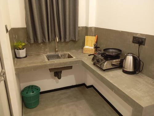 een aanrecht met een wastafel en een fornuis bij Amandaa Homestay in Dikwella