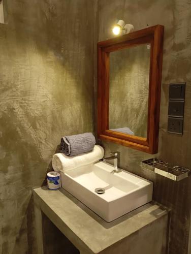 a bathroom with a white sink and a mirror at Amandaa Homestay in Dickwella