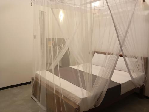 een slaapkamer met een bed met een klamboe bij Amandaa Homestay in Dikwella