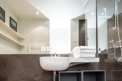 une salle de bain avec un lavabo et une douche en verre dans l'établissement Marais Centre Pompidou ID 233, à Paris