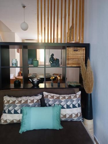 a living room with a couch with pillows at Lambriana's House beach front in Thessaloniki