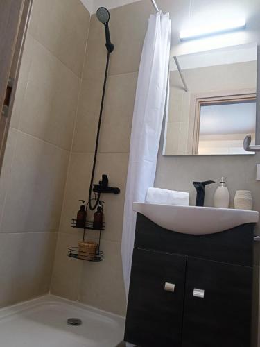 a bathroom with a sink and a mirror at Lambriana's House beach front in Thessaloniki