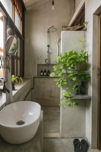 a bathroom with a white sink and some plants at LEJU 8 樂居 Loft Living by the River with Open Air Bath in Malacca