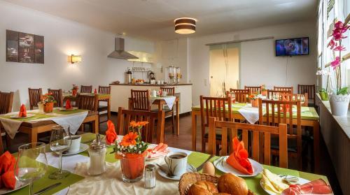a restaurant with tables and chairs with food on them at Pension Haus Marga in Bad Kissingen