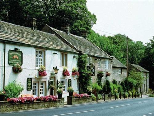 a white building on the side of a street at The Chequers Inn in Grindleford Bridge