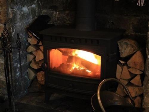 a fireplace with a fire inside of it at The Chequers Inn in Grindleford Bridge