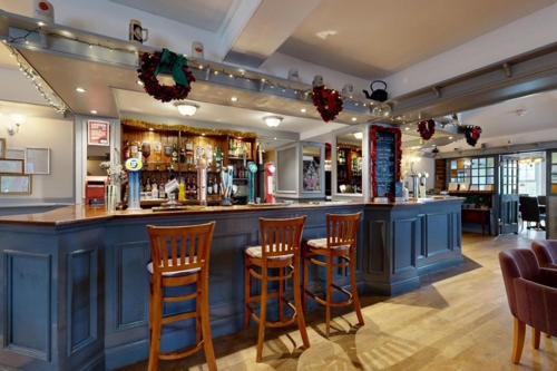 a bar with wooden bar stools in a restaurant at The Briery in Workington
