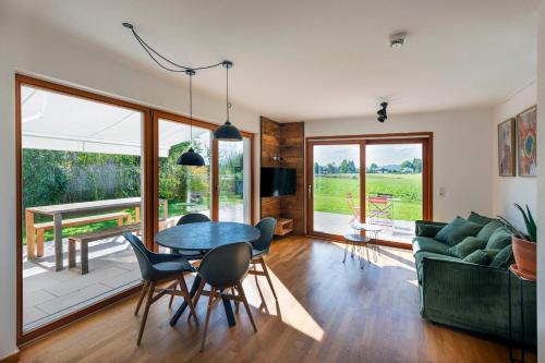 een woonkamer met een tafel, stoelen en een bank bij BergSeeMomente in Breitbrunn am Chiemsee