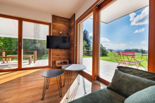een woonkamer met een bank, een tafel en stoelen bij BergSeeMomente in Breitbrunn am Chiemsee