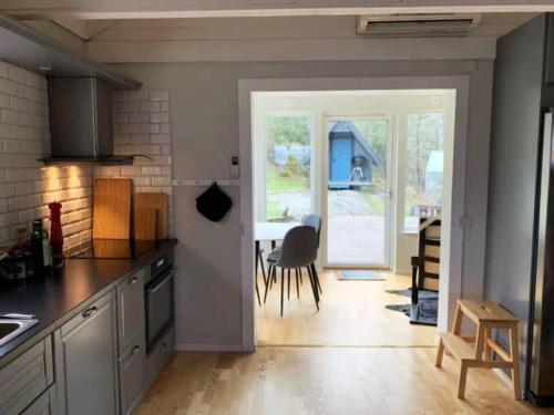 Cottage near the beach with guesthouse SE09165 في Sörtegen: مطبخ مع باب مفتوح على صالة طعام