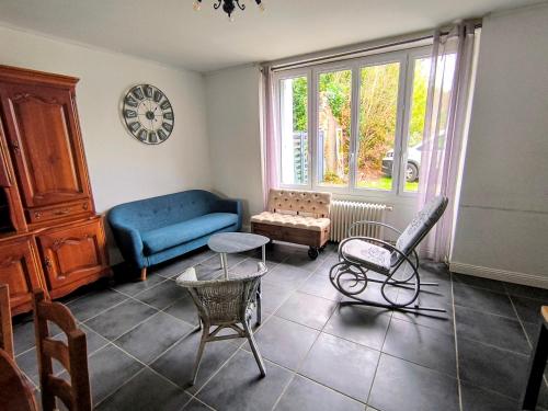 Gîte Le Coquelicot Jardins de Marie في Cerizay: غرفة معيشة مع أريكة زرقاء وكرسي