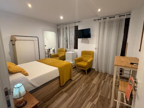 ein Hotelzimmer mit einem Bett und einem Stuhl in der Unterkunft Restaurante & Hotel Rural El Mirador de Trevejo,ideal para parejas in Villamiel