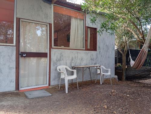 a table and two chairs in front of a house at El Romance in Jaureguiberry