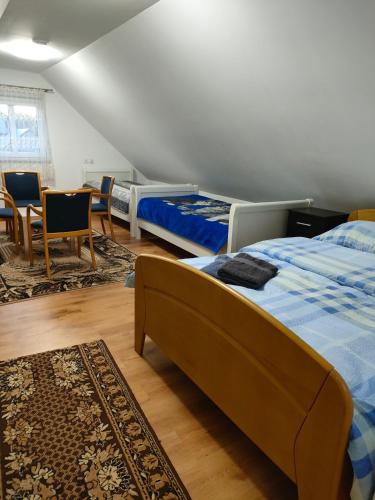 a bedroom with two beds and a table and chairs at Gosciniec in Kodeń