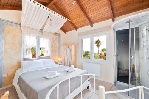 Un dormitorio con una cama tamaño king y una ducha. en Villa Suites Lagonisi Luxury, en Lagonisi