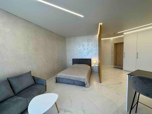 a bedroom with a bed and a couch at New luxury modern Apartment in Šnipiškės in Vilnius