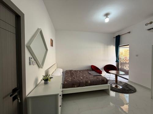 a bedroom with a bed and a mirror and a table at Al Karama Studio in Abu Dhabi
