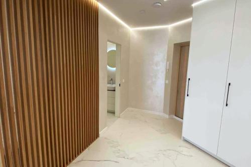 a hallway with white walls and a wooden wall at New luxury modern Apartment in Šnipiškės in Vilnius