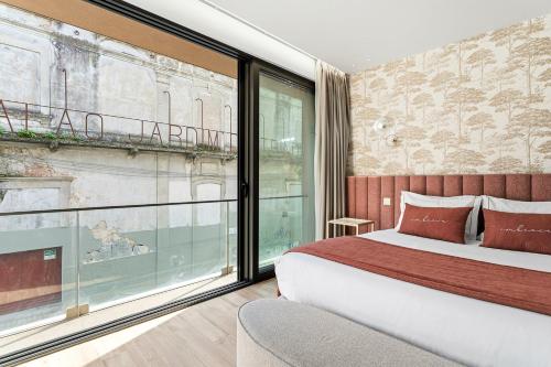 a bedroom with a bed and a large window at GuestReady - Alma Invicta in Porto