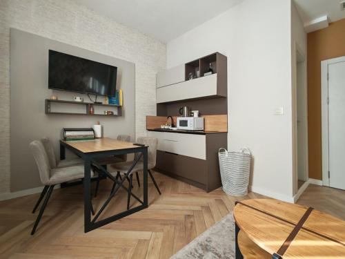 a living room with a dining room table and a kitchen at KONDOR apartmani in Vrnjačka Banja