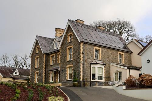 a large brick house with a solar roof at Y Seren Hotel & Restaurant in Carmarthen