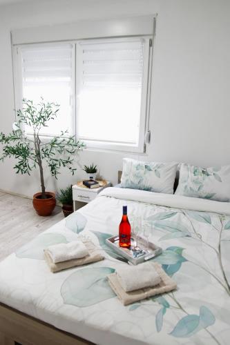 a bed with a tray with a bottle of wine on it at Vikend Kuća Luka in Batrovci