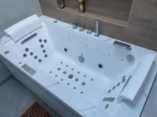 a white bath tub sitting in a bathroom at La Parenthèse Balnéo in Donzère