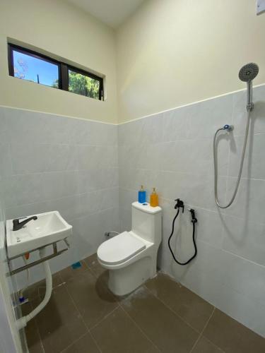 a bathroom with a shower and a toilet and a sink at Ayah Su Homestay Atas Tol in Kuala Terengganu