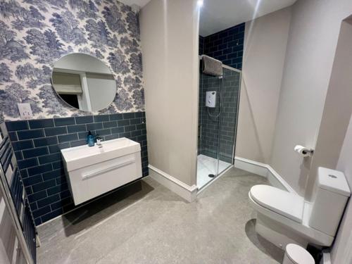 ein Badezimmer mit Toilette, Waschbecken und Spiegel in der Unterkunft 4 ABBOTSFORD , KELSO Town Centre in Kelso