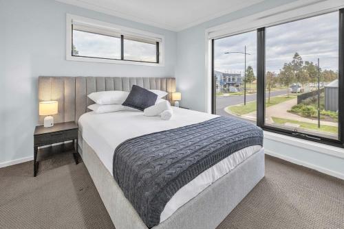 a bedroom with a bed and a large window at Bright & Cozy 4-Bed Home in Rockbank in Rockbank