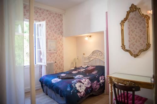 a bedroom with a bed and a mirror on the wall at La Roseraie in Lodève