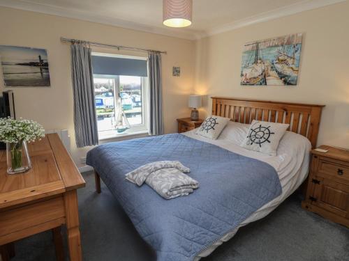 a bedroom with a large bed with a blue blanket at Daisy Lodge in Norwich