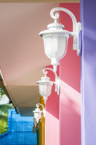 a row of street lights in front of a colorful wall at Tum Baan Suan ตุ่มบ้านสวน in Chanthaburi