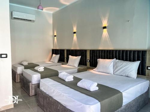 drie bedden in een kamer met lampen erboven bij Dahab Now in Dahab