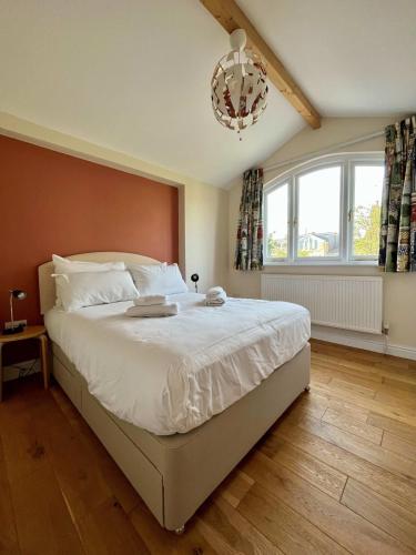 a bedroom with a large bed and a chandelier at Charming 1 bed super central Terraced House in Cambridge