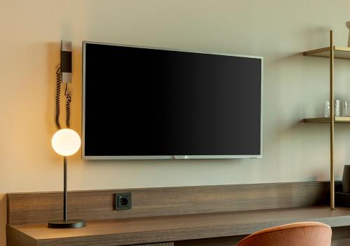 a flat screen tv hanging on a wall at Corendon Amsterdam Schiphol Airport, a Tribute Portfolio Hotel in Badhoevedorp