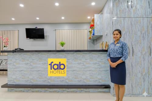 a woman standing in front of a reception desk at FabHotel AI Howrah in Kolkata